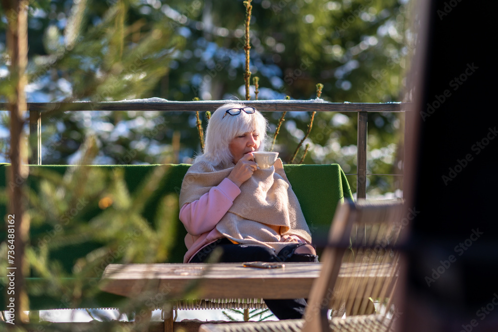 Lady enjoying a drink at a table on the terrace