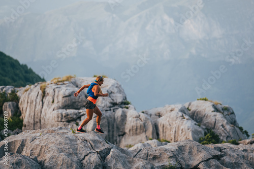 An extreme skyrunner is running on rocky mountains.