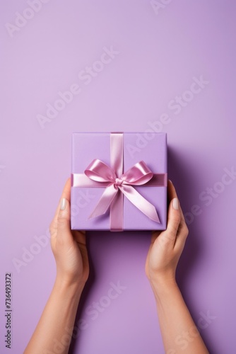 Female hands holding a purple gift box on a purple background. Generative AI.