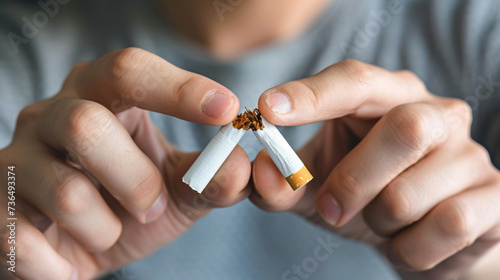 Hands are shown breaking a cigarette in half, symbolizing the decision to quit smoking and lead a healthier lifestyle.