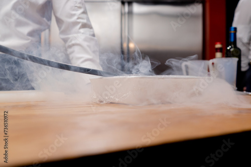 close-up of the container hidden with cling film the smoking process using tube going into the hole of the container
