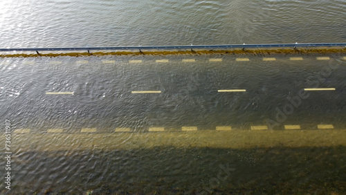 Samochody na zalanej wodą drodze po powodzi. 