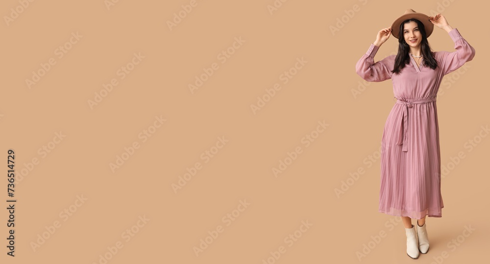 Beautiful young woman in stylish pink dress and hat on beige background with space for text Beautiful young woman in stylish pink dress and hat on beige background with space for text