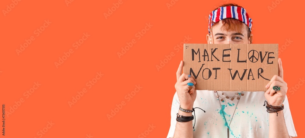 Male hippie holding placard with text MAKE LOVE NOT WAR on orange background with space for text - obrazy, fototapety, plakaty 