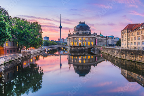 Sunrise in Berlin. Skyline in the center of the capital of Germany. Historical buildings on the Museum Island and television tower with reflections on water surface from the Spree river