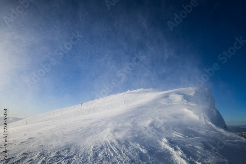 Dumbier, Nizke Tatry, Low Tatras, Slovakia. Heavy wind and windstorm on the top of mountain. Extreme weather on the peak and summit in the winter. Flying snow as blurred smudges. Vignetting. photo
