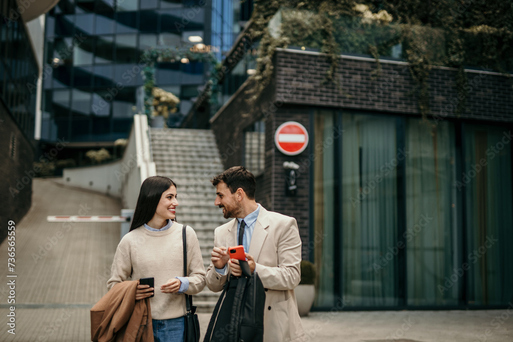 Two business partners in animated discussion during their daily walk to the office in the city Two business partners in animated discussion during their daily walk to the office in the city