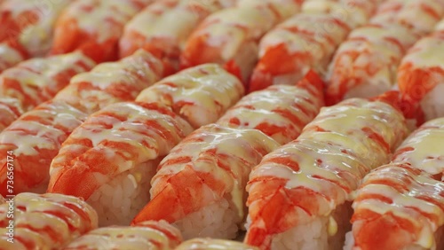 Traditional Japan rice dish sushi with shrimp on tom close-up. Asian popular food with sea food and rice. Sushi or sashimi on local street food market outdoor.  photo