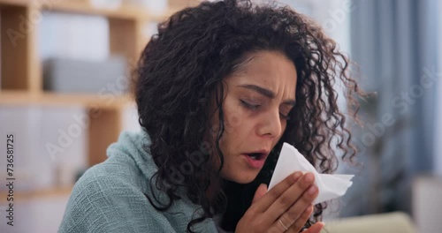 Female person, sick and sneeze at home, sofa and blanket to relax, recover and keep warm for winter season. Woman, flu and tissue with influenza, disease and allergy at the house to isolate and cough photo