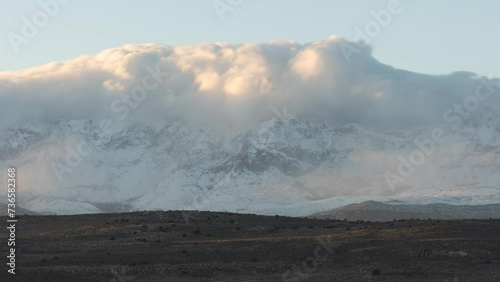 4k time lapse video of clouds driven by a north wind pouring over the peaks of Pine Valley Mt. in Southern Utah at sunset and dissipating as they slide down the mountain face. photo