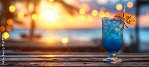 Blue hawaiian cocktail in tropical setting with blurred beach background and copy space