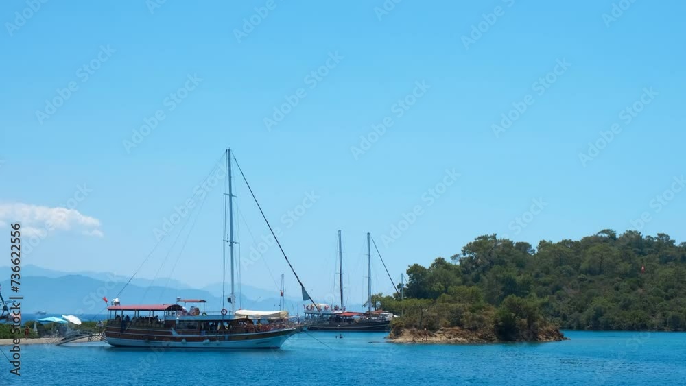 Moorage area with yachts. A view of traveling ship docked by the tropical shore in the sun. A concept of sea trip during summer weekend. Moorage area with yachts. A view of traveling ship docked by the tropical shore in the sun. A concept of sea trip during summer weekend.