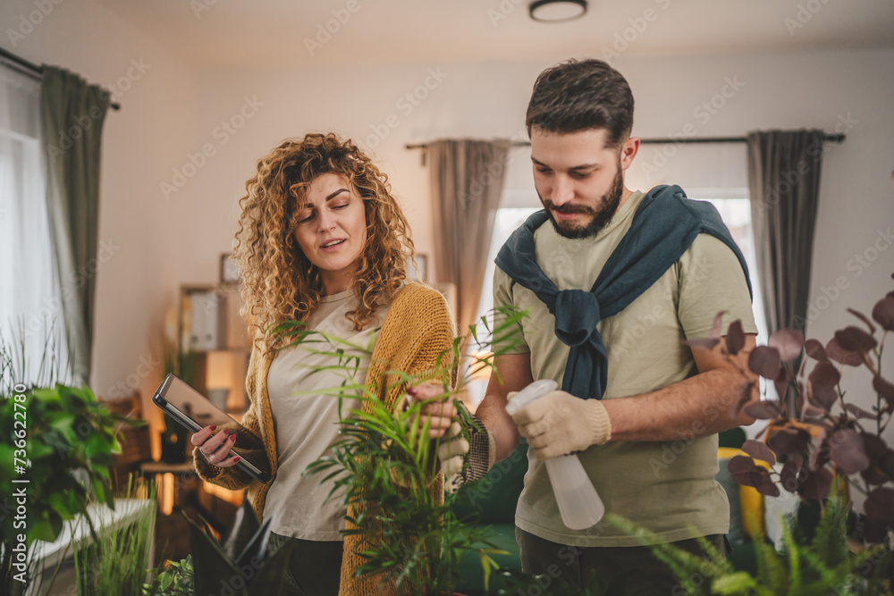 Couple man and woman wife and husband take care of plants at home