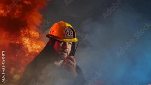 A firefighter communicates on a walkie-talkie during a fire  photo