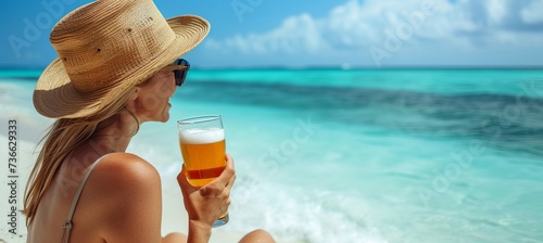 Beautiful woman enjoying a beer on a tropical paradise beach on a sunny summer day with copy space