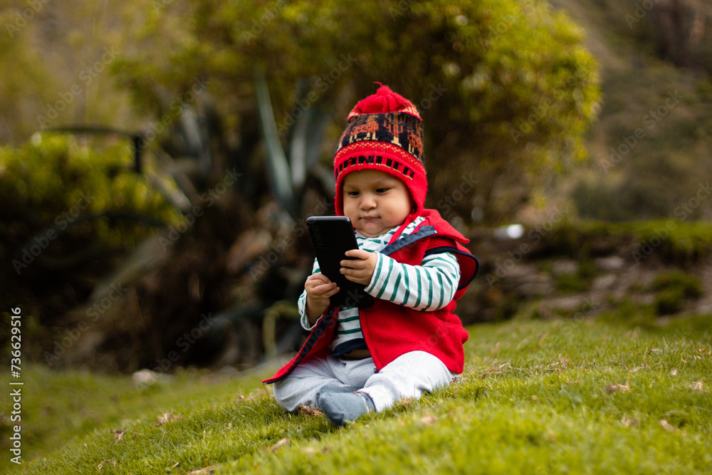 Conexión cultural Bebé con chullo tejido y celular en mano,estilo de vida,aire libre Conexión cultural Bebé con chullo tejido y celular en mano,estilo de vida,aire libre