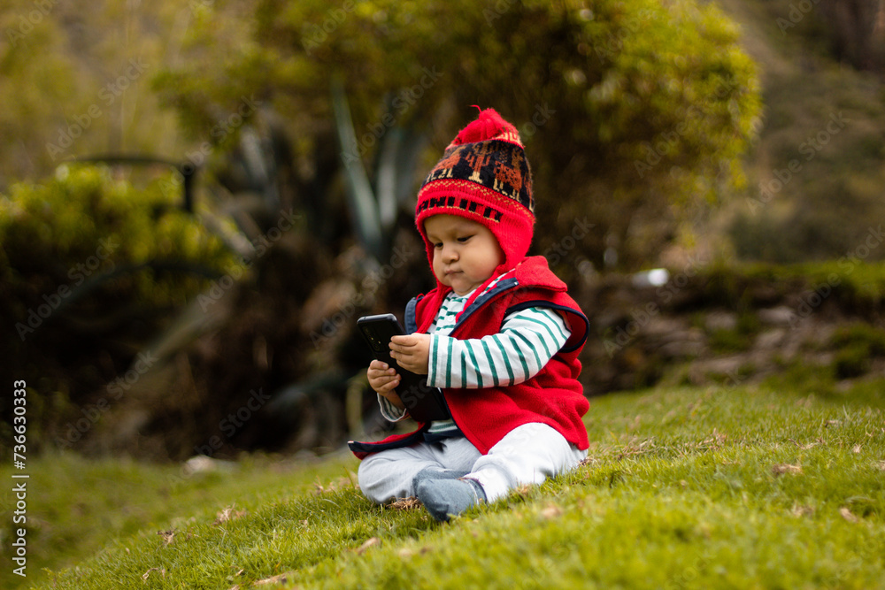 Conexión cultural Bebé con chullo tejido y celular en mano,estilo de vida,aire libre Conexión cultural Bebé con chullo tejido y celular en mano,estilo de vida,aire libre