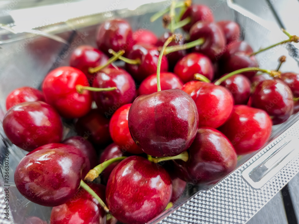 Φωτογραφία Ripe red cherries in a clear clamshell berry container