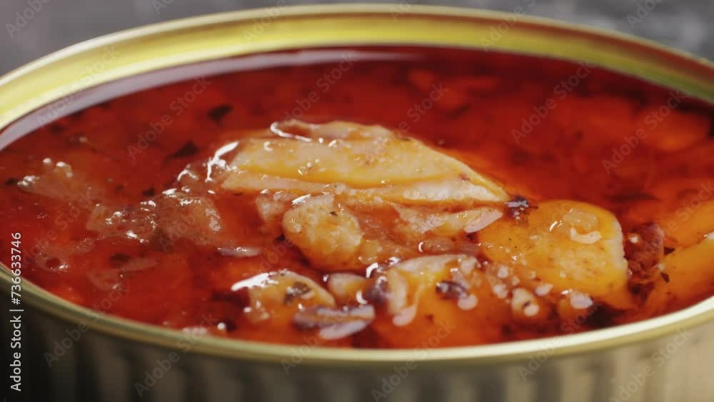 Opening canned octopus squid fish can, man open the canned seafood on the table. Close up on professional kitchen. Opening canned octopus squid fish can, man open the canned seafood on the table. Close up on professional kitchen.