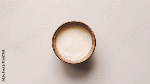 An aerial perspective of a bowl filled with cream, set against a white background