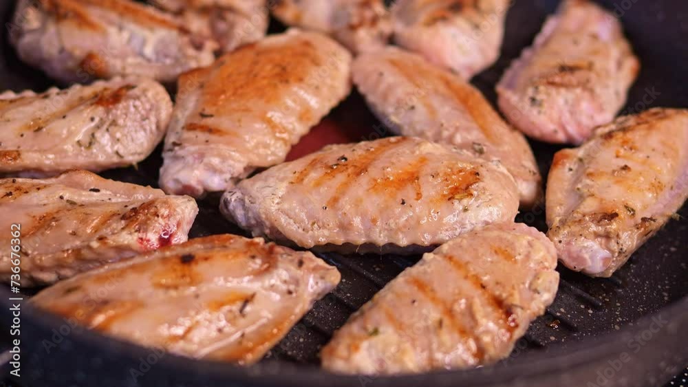 Fried fast-food chicken wings on skillet. Observe how fried wings elevate cholesterol levels. Delve into the effects of cholesterol as fast-food sizzles, stimulating the sense. Cholesterol is harmful