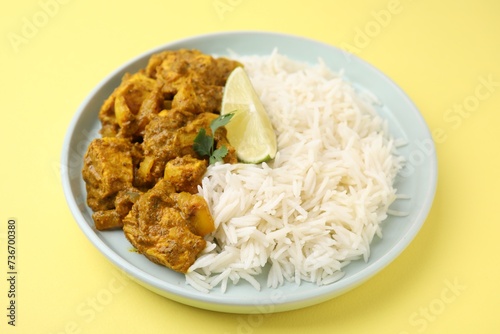 Delicious chicken curry with rice on yellow background, closeup