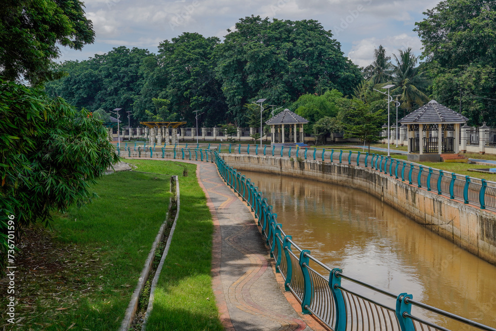 The river in the beautiful Serpong city park with a bright sky as a background. - obrazy, fototapety, plakaty 