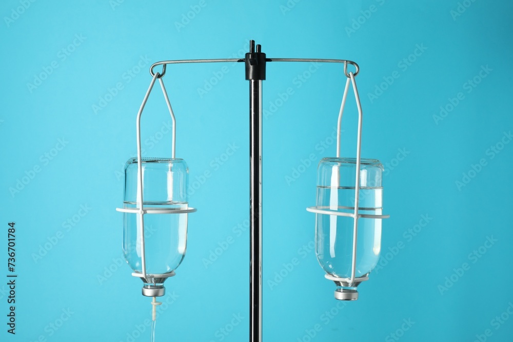 IV infusion set on pole against light blue background IV infusion set on pole against light blue background