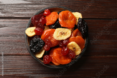 Mix of delicious dried fruits on wooden table, top view