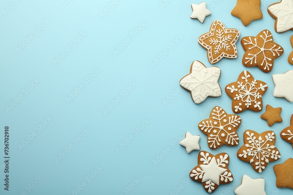 Tasty star shaped Christmas cookies with icing on light blue background, flat lay. Space for text Tasty star shaped Christmas cookies with icing on light blue background, flat lay. Space for text