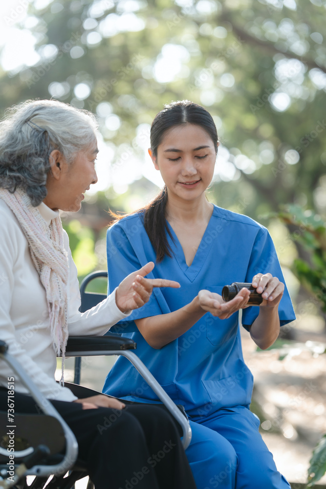 Compassionate Asian woman provides care to  elderly person in wheelchair outdoors. Engaging in physical therapy, happiness, encouraging positive environment for mature individuals with grey hair.