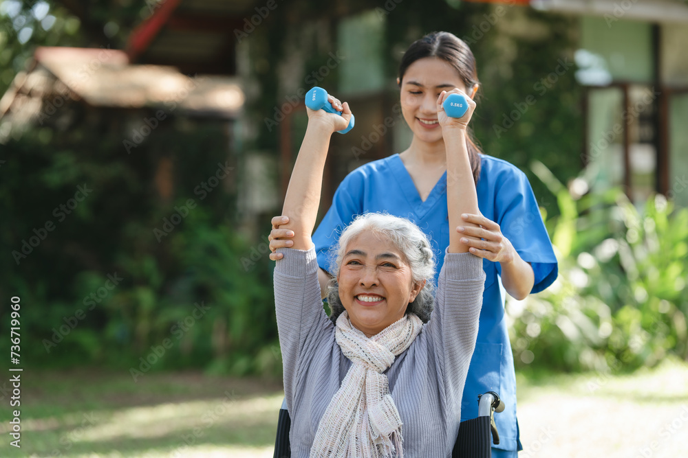 Compassionate Asian woman provides care to elderly person in wheelchair outdoors. Engaging in physical therapy, happiness, encouraging positive environment for mature individuals with grey hair. Compassionate Asian woman provides care to elderly person in wheelchair outdoors. Engaging in physical therapy, happiness, encouraging positive environment for mature individuals with grey hair.