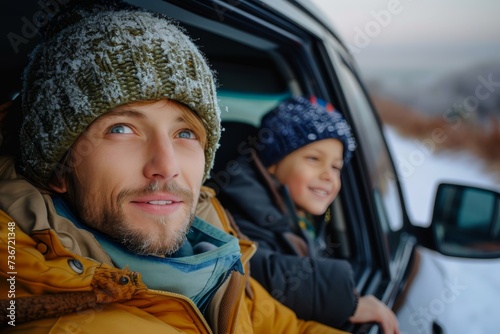 A smiling dad and joyful son head out on a winter adventure, looking out from their car