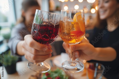 A vibrant moment as two people clink glasses filled with colorful cocktails in a lively setting