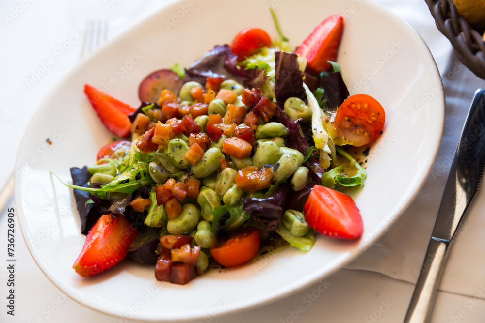 Salad with candied beans, strawberry and bacon marinated with soy and honey