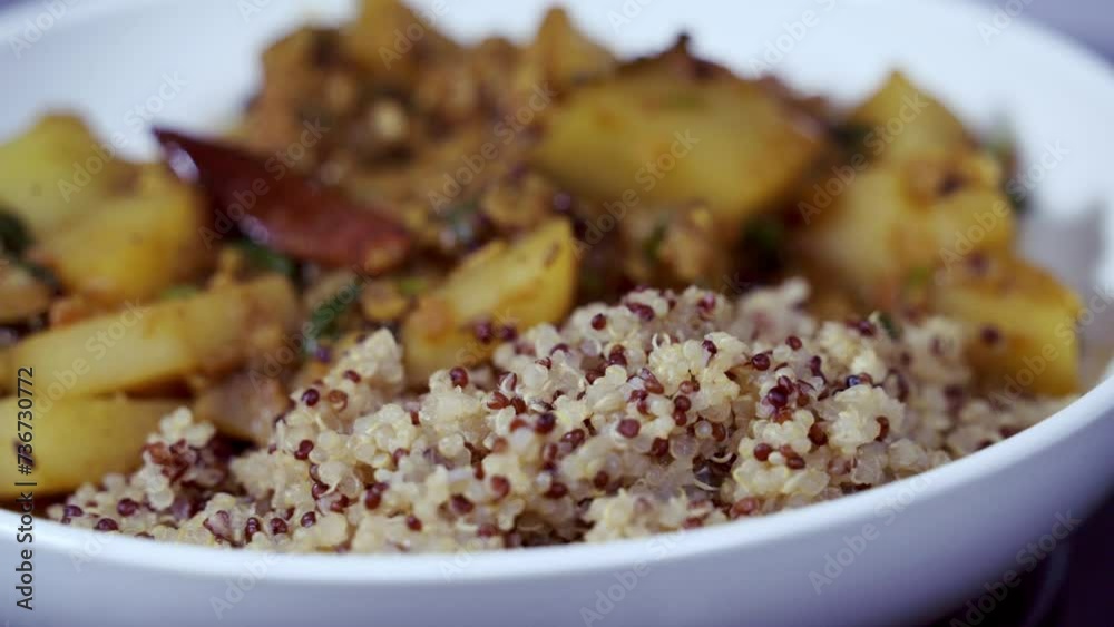 Close up shot of papaya curry rotating in a white bowl with quinoa on the side Close up shot of papaya curry rotating in a white bowl with quinoa on the side