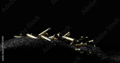 Close up shot of loose gunpowder pile with .22 Long Rifle bullets falling on photo