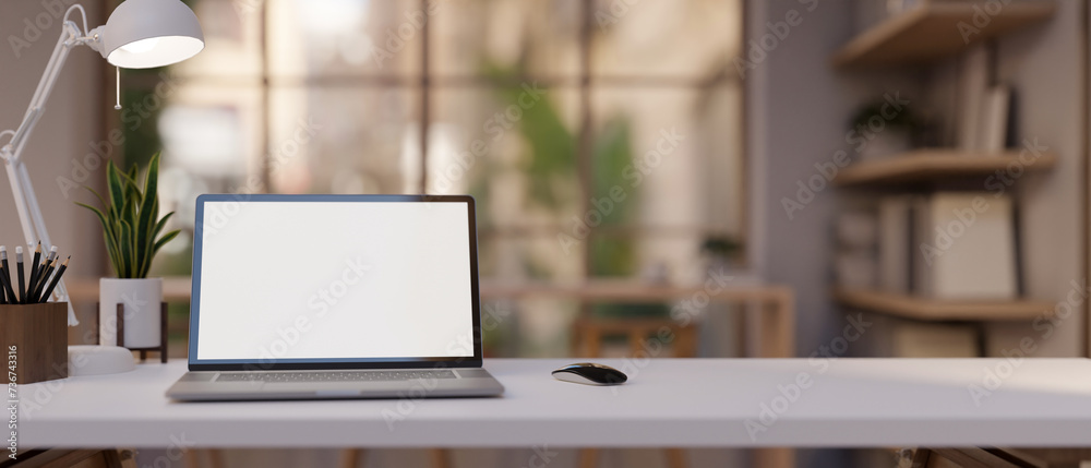 A white table with a laptop computer and decor is featured in a modern and comfortable office room. A white table with a laptop computer and decor is featured in a modern and comfortable office room.