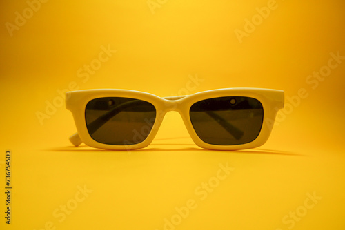 Hipster eyeglasses in pastel frames on a yellow background. Stylish eyeglasses. Retro fashion bold frame style. Space for text.