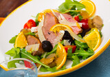 Fresh salad with duck breast, greens and tomatoes served on plate