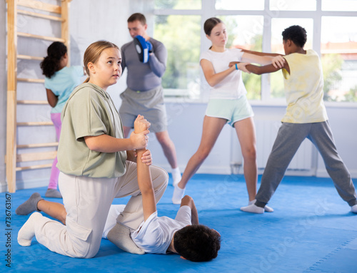 Self-defense - girl twists the arm of an attacking boy during self-defense training