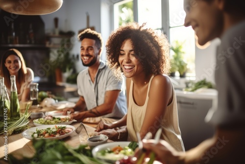 Group of friends sharing a meal and laughter in a bright kitchen