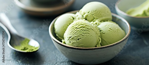 a bowl of green tea ice cream with a spoon in it . High quality photo