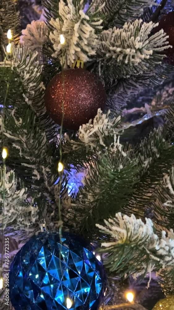 Christmas tree with ornaments on with flickering and color changing lights in different colors in part in holiday season. High quality Christmas tree with ornaments on with flickering and color changing lights in different colors in part in holiday season. High quality