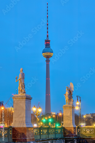 The famous Television Tower of Berlin with two white sculptures at twilight