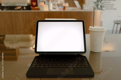 Front view of notebook showing white blank screen while someone working online at cafe.