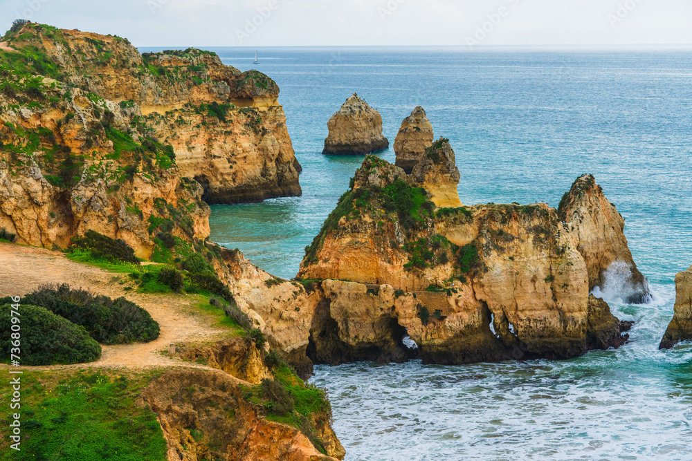 Rugged Algarve coastline with towering cliffs and crashing Atlantic waves creates a stunning seascape