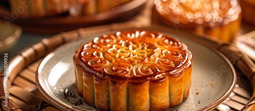 A moon cake  a traditional Chinese dessert  is placed on a plate on a wooden tray. This baked good is a popular finger food during the MidAutumn Festival