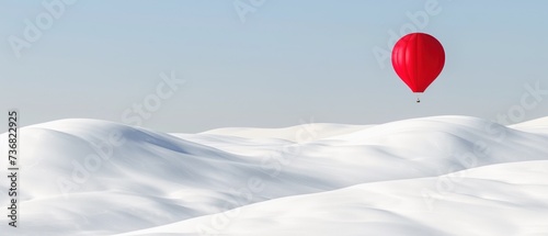 a red hot air balloon flying over a snow covered mountain covered in a blanket of white, low lying snow. photo