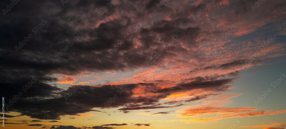 Fototapeta premium Sunset Clouds background. Dramatic Clouds Sunset Background. Sky with clouds in Sunrise. Sunrise with clouds in various shapes background. Calm Cloud.